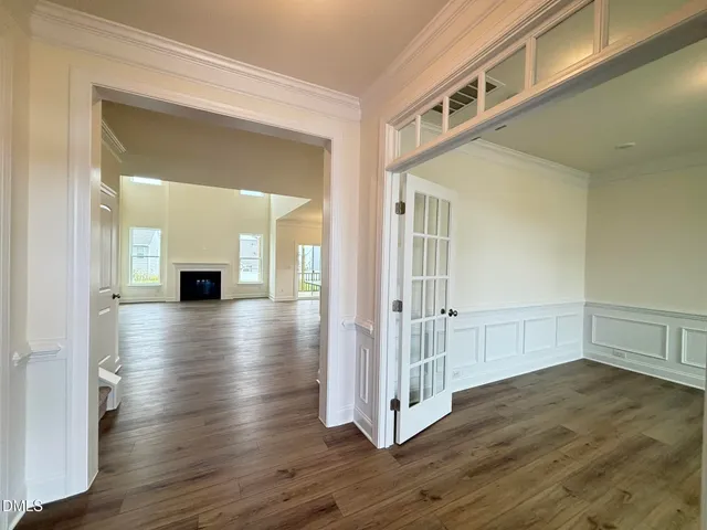 a view of a hallway with wooden floor and a living room