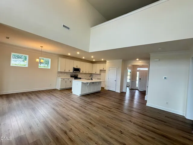 an empty room with wooden floor and a fireplace