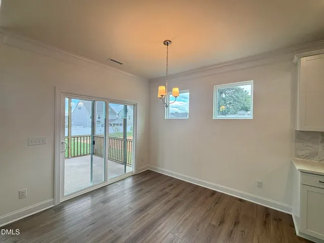 a view of a kitchen with wooden floor and windows