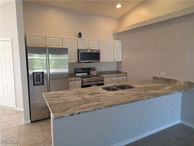 a kitchen with kitchen island granite countertop a sink stainless steel appliances and counter space