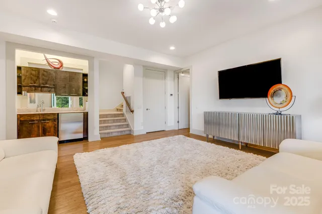 a living room with furniture a flat screen tv and a large window