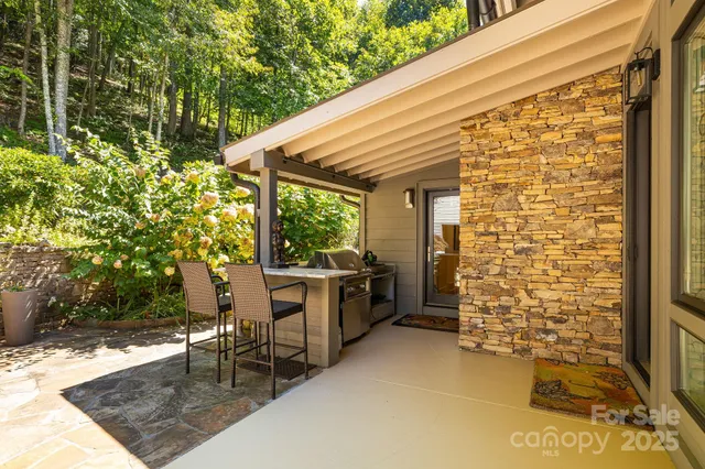 a porch with a table and chairs and potted plants
