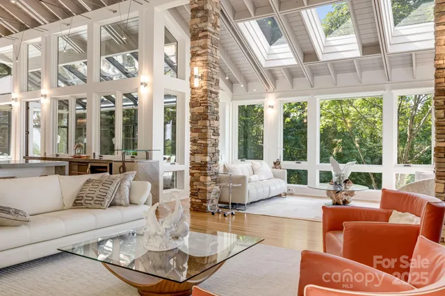 a living room with furniture and floor to ceiling windows