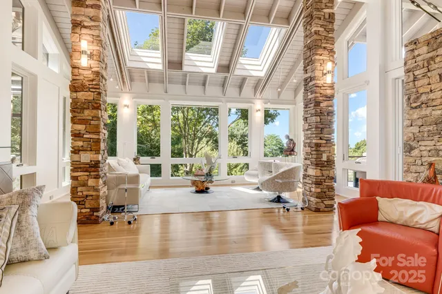a living room with furniture and floor to ceiling windows