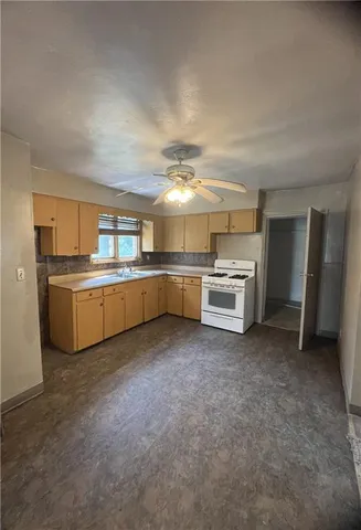a kitchen with granite countertop a stove sink and cabinets