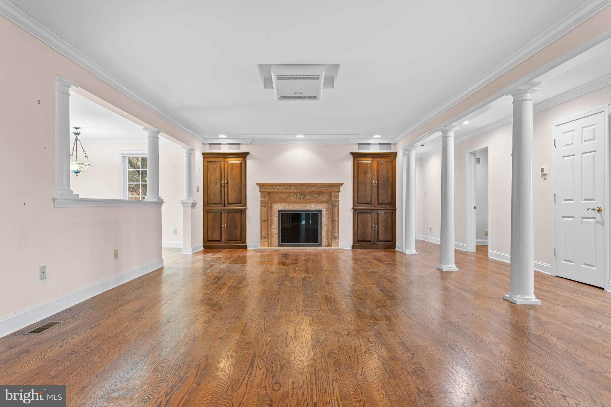 753 Mustin Lane Villanova, PA 19085 - Photo 5 of 40 an empty room with wooden floor fireplace and windows