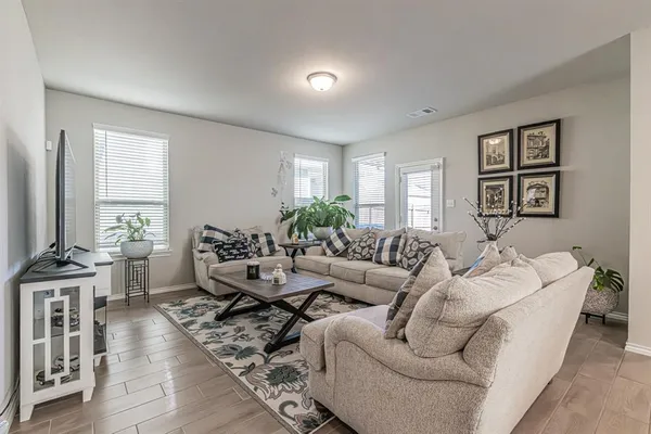 a living room with furniture wooden floor and a large window
