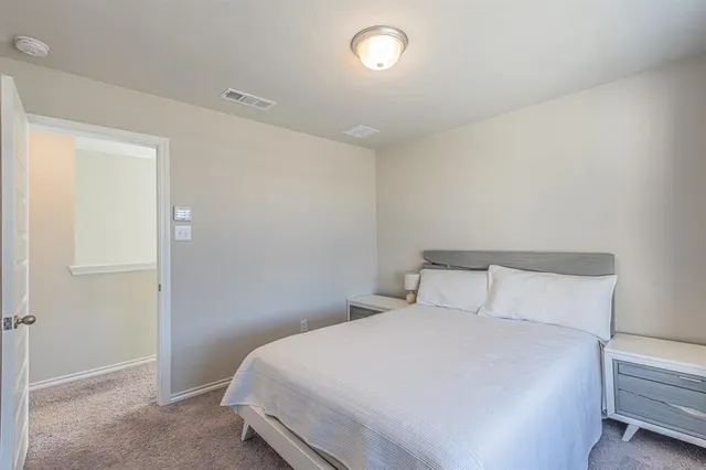 a bedroom with a bed and a night stand