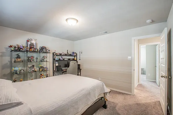 a bed room with a bed and a view of kitchen