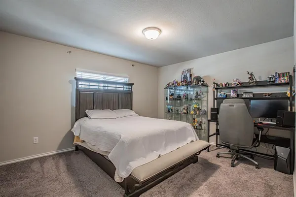 a bedroom with a bed and a desk in it
