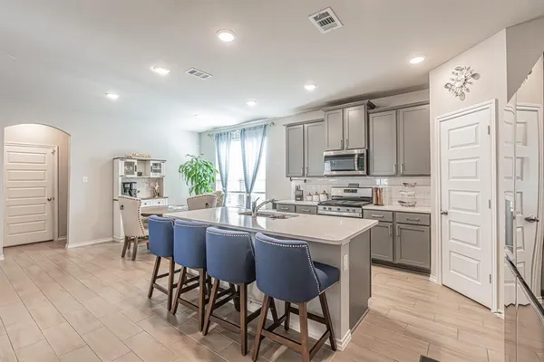 a kitchen with appliances a sink a counter top space and cabinets