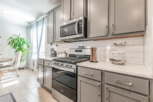 a kitchen with stainless steel appliances white cabinets and a stove top oven