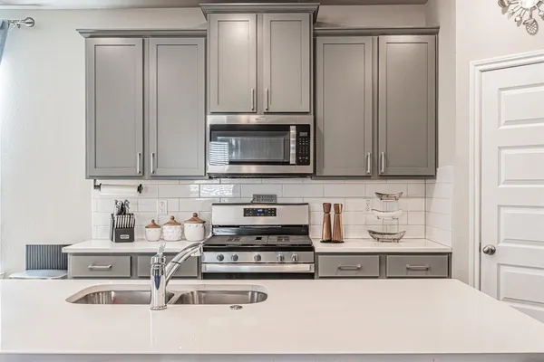 a kitchen with stainless steel appliances granite countertop a refrigerator a stove and a sink