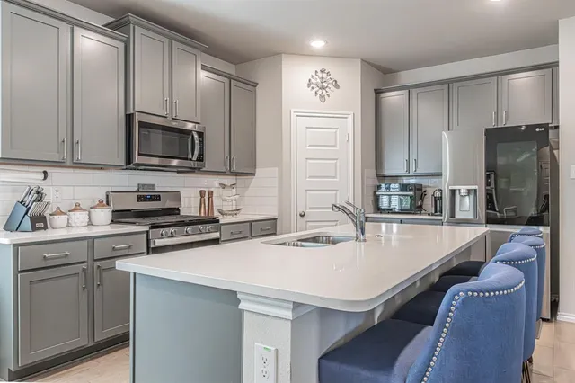a kitchen with stainless steel appliances a stove a sink a microwave and cabinets
