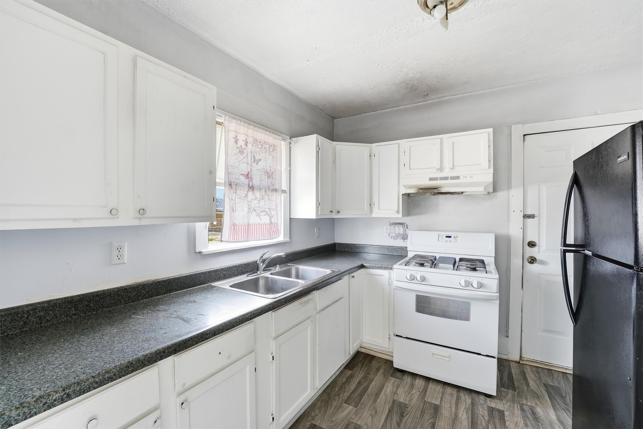 2420 Stevens Street Houston, TX 77026 - Photo 9 of 15 a kitchen with a white cabinets and white appliances