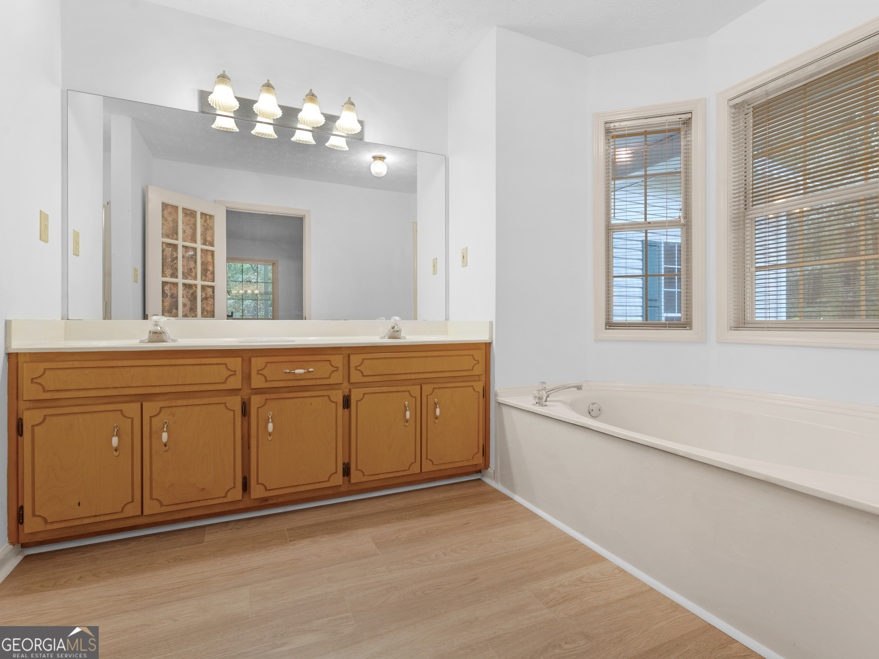 12012 Turner Road Hampton, GA 30228 - Photo 18 of 38 a spacious bathroom with a granite countertop sink a large mirror and a bathtub with shower