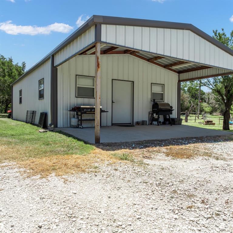 785 Tweedy Road Valley Mills, TX 76689 - Photo 35 of 40 Metal-sided building featuring a covered concrete patio and a gravel approach
