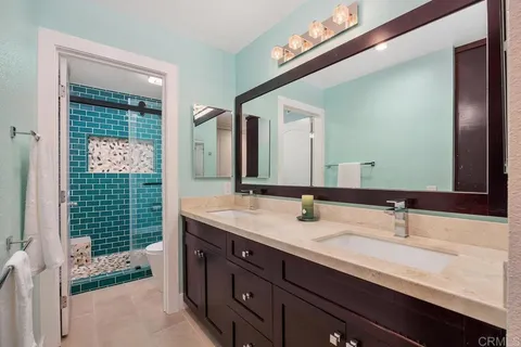 a bathroom with a double vanity sink and a mirror
