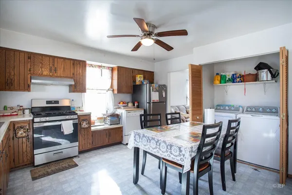 a kitchen with a stove a refrigerator and a dining table