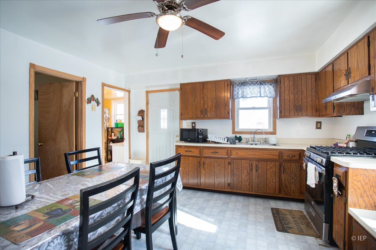 1104 Cora Street Joliet, IL 60435 - Photo 7 of 20 a kitchen with stainless steel appliances granite countertop wooden cabinets a dining table and chairs