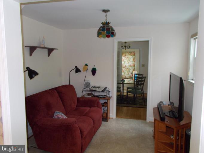 9504 Monroe Street Silver Spring, MD 20910 - Photo 8 of 26 a living room with furniture a flat screen tv and a refrigerator