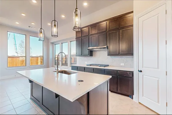 a kitchen with stainless steel appliances granite countertop a sink a oven and wooden floors