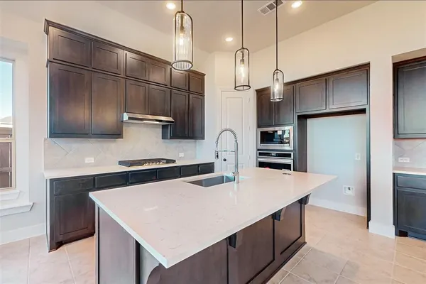 a kitchen with stainless steel appliances a stove refrigerator sink and microwave