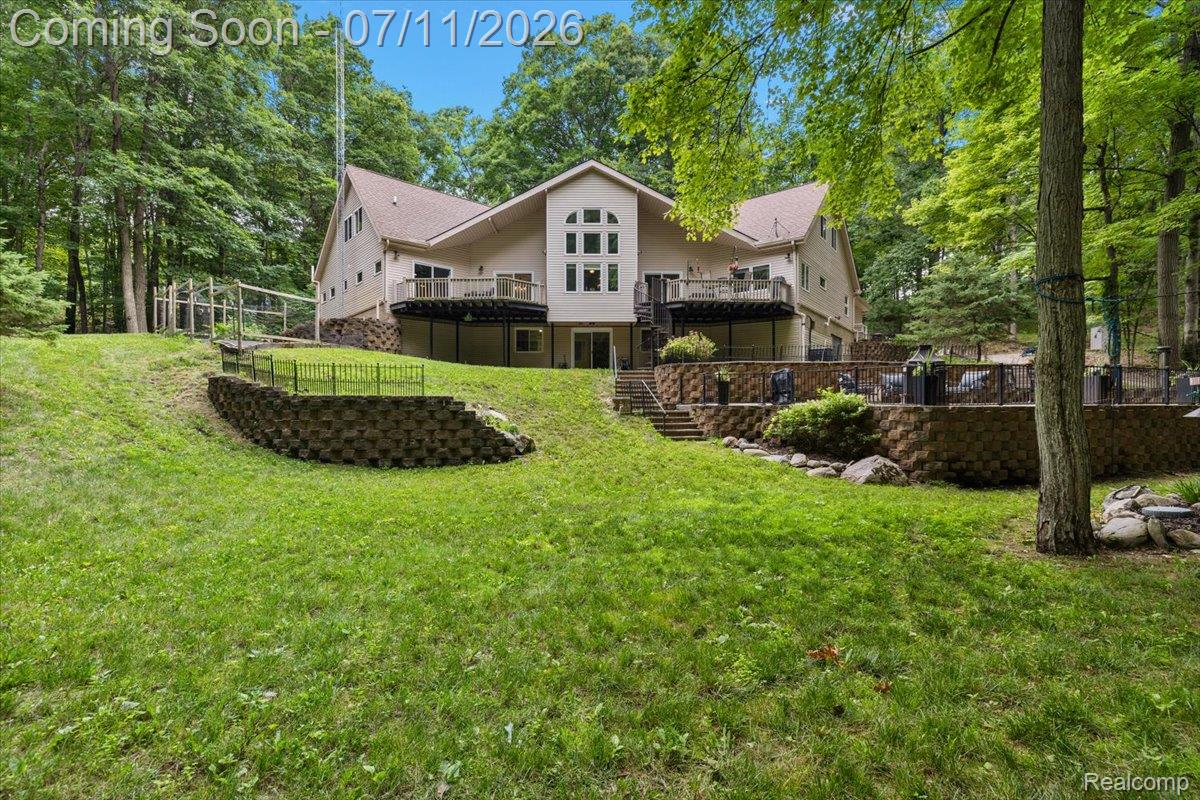 4219 Gardner Road Metamora, MI 48455 - Photo 81 of 87 Rear exterior featuring multiple decks and a lower-level patio with retaining walls