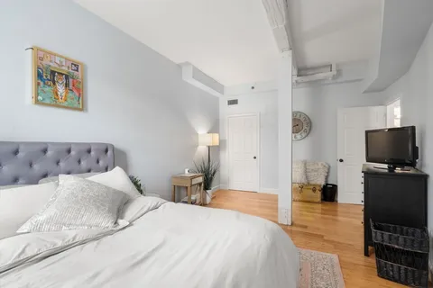 a bedroom with a bed and a flat screen tv