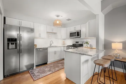 a kitchen with kitchen island granite countertop stainless steel appliances cabinets a sink and a counter top space