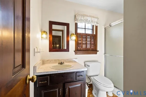 a bathroom with a sink toilet a mirror and shower