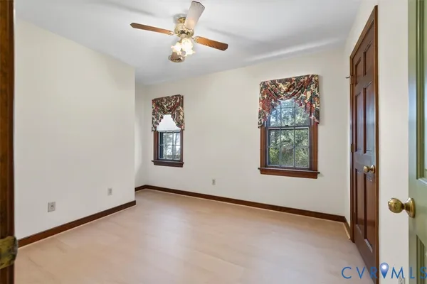 an empty room with windows and fan