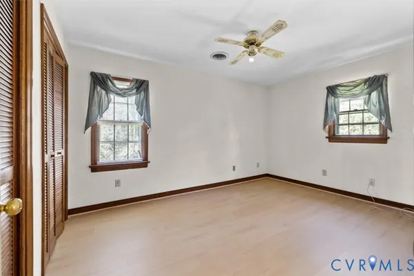 an empty room with a window and a ceiling fan