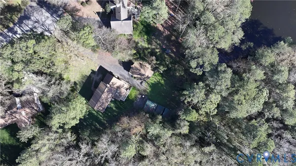 a aerial view of residential house with outdoor space and trees all around