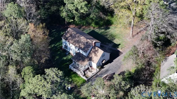 an aerial view of a house with a yard and large trees