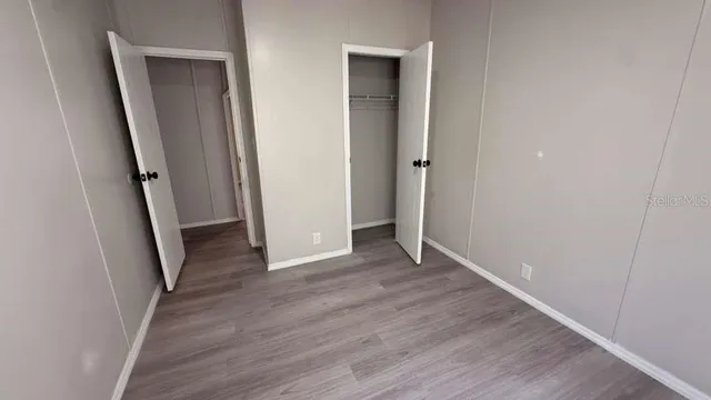 an empty room with wooden floor and closet