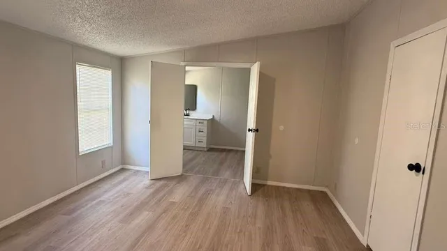 a view of a room with wooden floor and a window