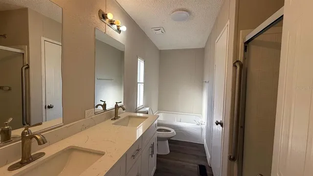 a bathroom with a sink double vanity granite tub and shower