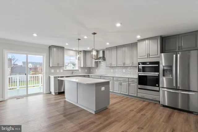 a large kitchen with a center island stainless steel appliances and cabinets