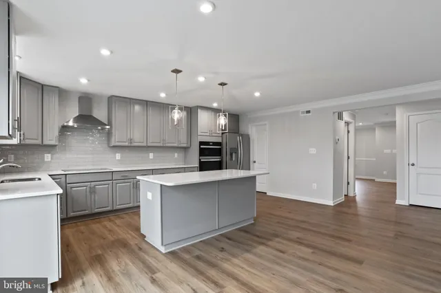 a large kitchen with cabinets and wooden floor