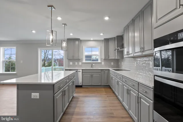 a large kitchen with stainless steel appliances kitchen island granite countertop a sink a counter space and stainless steel appliances