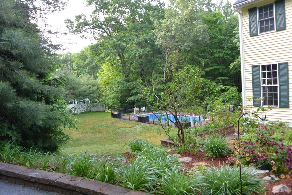 260 Manchaug Road Sutton, MA 01590 - Photo 5 of 29 a view of a backyard with plants and large trees
