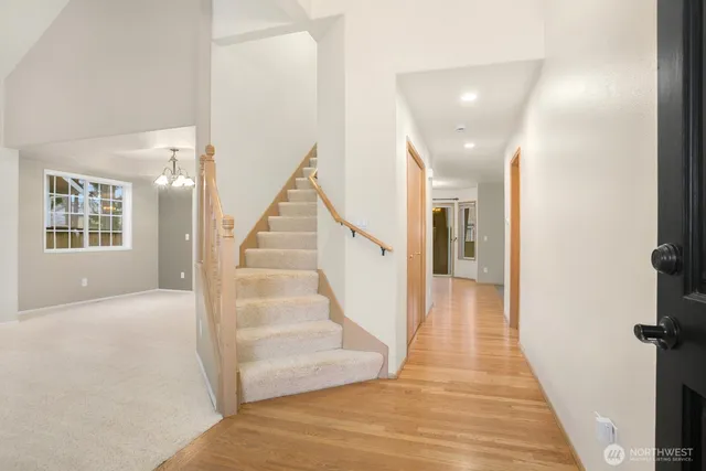 a view of a hallway with wooden floor and staircase