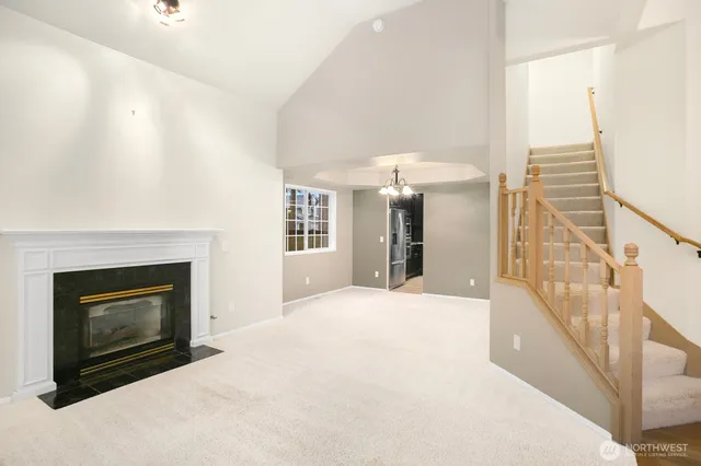 a view of an empty room with fireplace and a window