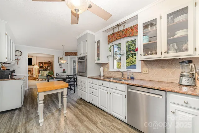 a large kitchen with stainless steel appliances granite countertop a lot of counter space and a dining table