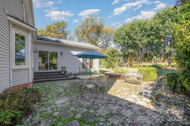 a view of a house with backyard and sitting area