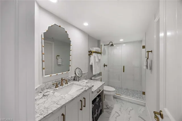 a bathroom with a granite countertop sink a toilet and shower