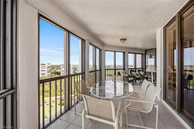 a dining room with furniture water view and a floor to ceiling window
