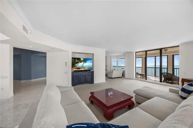 a living room with furniture a large window and flat screen tv
