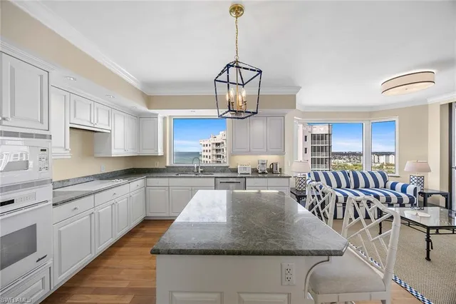 a kitchen with stainless steel appliances granite countertop a kitchen island a stove and white cabinets